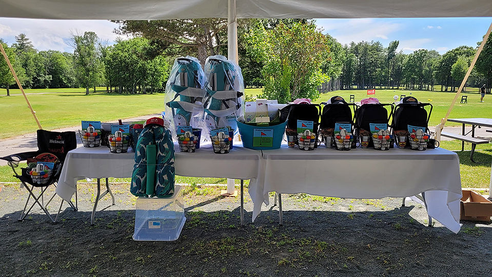 Bags and prizes sit on table at golf tournament 2024 BGCCA on course.