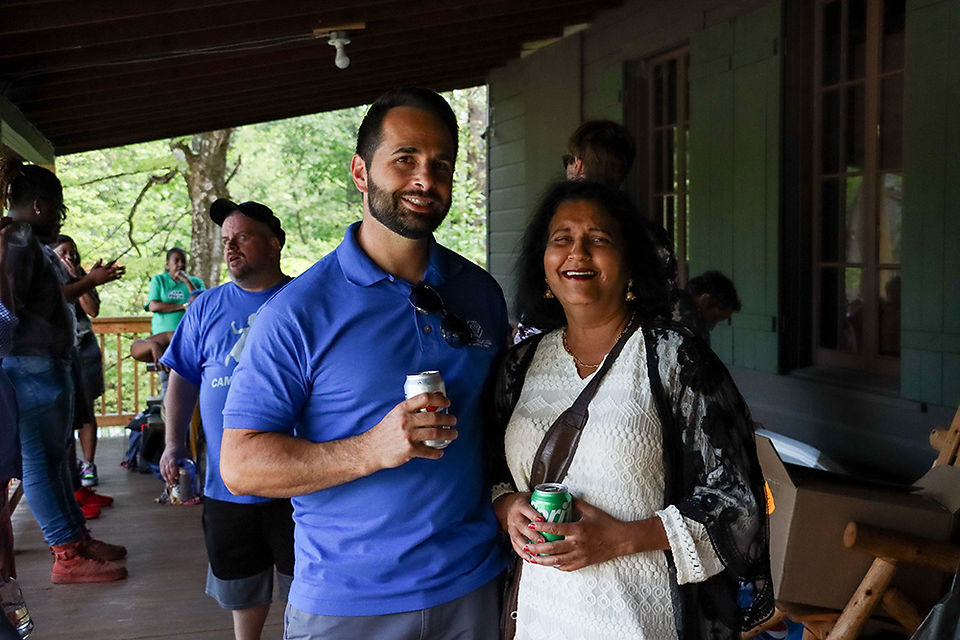 Two people smiling with drinks. BGCCA Announces the Departure of CEO Justin Reuter.
