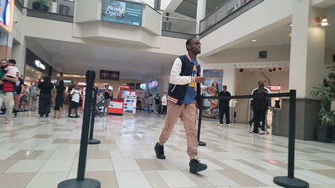Man walking through the mall with other people in the background.