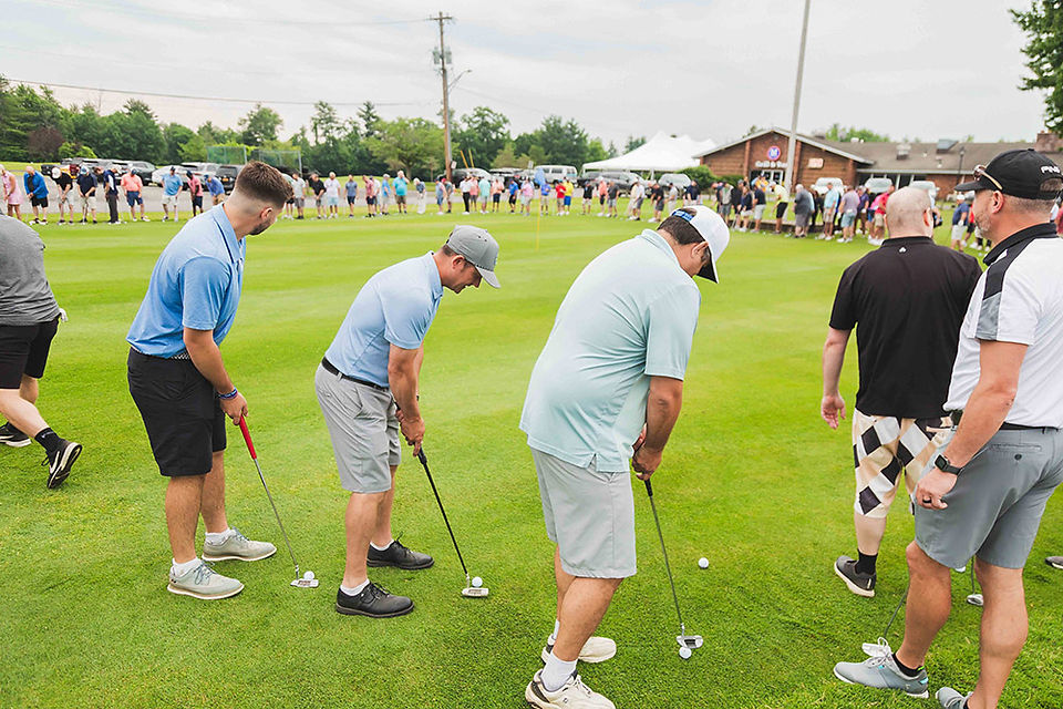 Golfers practice putting on green grass at the 2024 Golf Tournament BGCCA.
