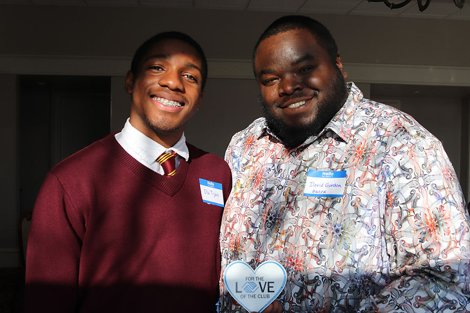 Two smiling men pose together with name tags,