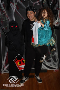 Woman and children in Halloween costumes, smiling for photo BGCCA