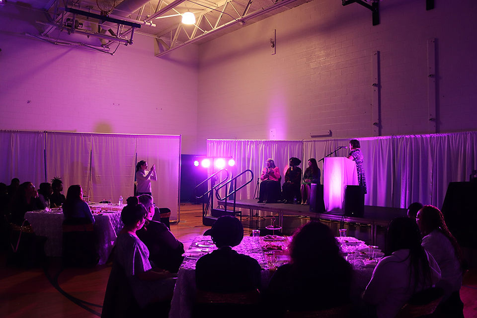People on stage with microphones in front of a crowd, BGCCA.