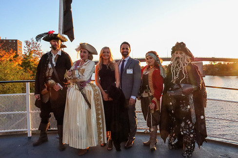 Group of people in pirate costumes posing at sunset, 2022 Gala: Pirate Cruise.