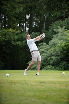 Golfer swinging at the ball on a green 2025 Golf Tournament BGCCA