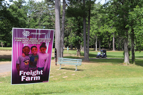 Freight Farm sign with children on golf course; 2023 BGCCA Golf Tournament