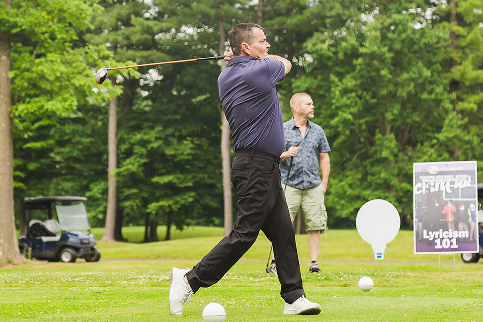 Golfer swinging club 
