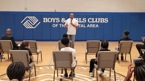 Man speaks to seated children, Boys & Girls Clubs of the Capital Area BGCCA.