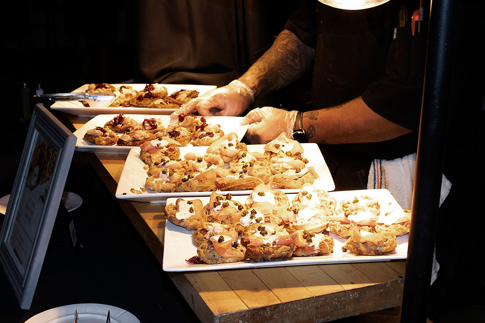 Chef plating desserts on serving trays with visible toppings and decor for serving.