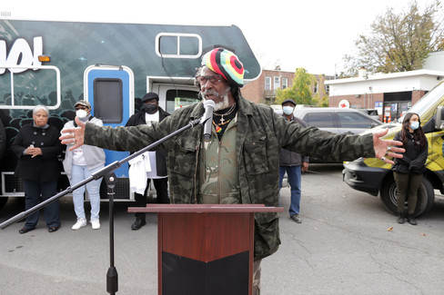 Man with arms outstretched speaks at podium with Stop the Violence - 11/11/21