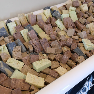 Colorful soaps in a white bin, various sizes and shapes. BGCCA