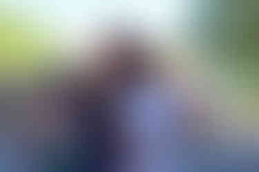 Family smiles for the camera in front of an outdoor event.