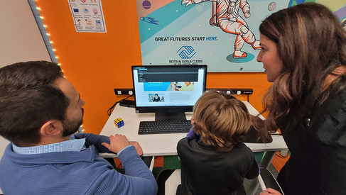 Boys and Girls Club members at a computer with 'Great Futures Start Here' BGCCA