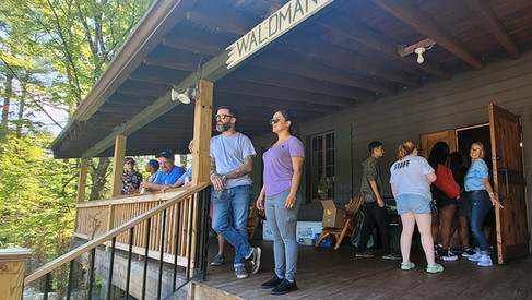 People standing on the porch with the word WALDMAN on top.