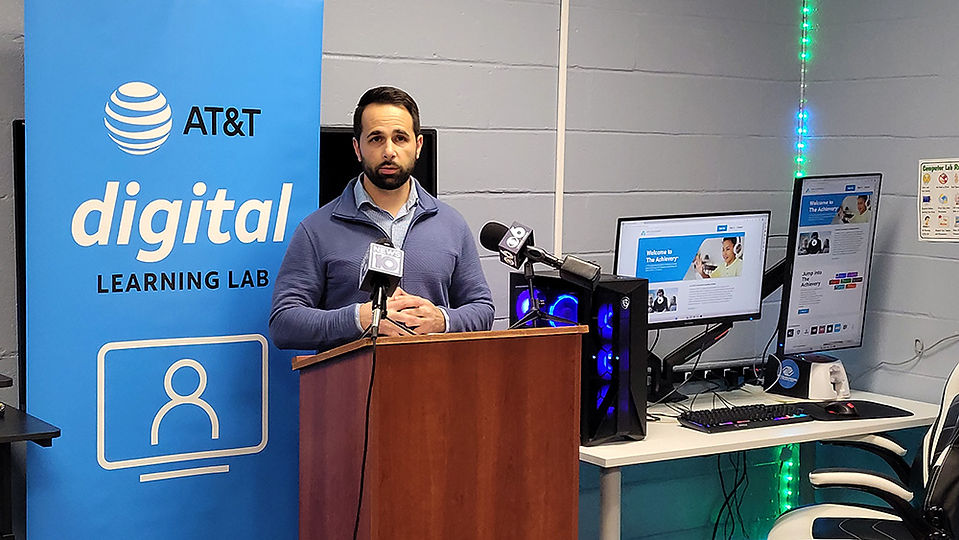 Man standing behind podium. AT&T Digital Learning Lab in background. CEO Transition.