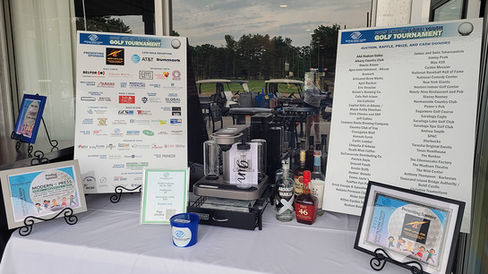 Coffee station at 2025 Golf Tournament with sponsors and golf carts in the background.