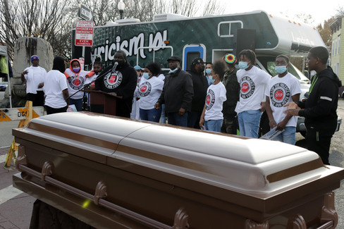 Mourners gather by a casket with Stop the Violence - 11/11/21, BGCCA event.