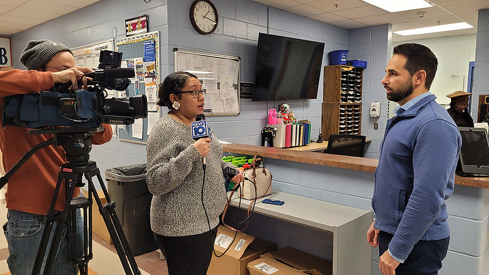 Woman reporter holding microphone, reporting inside a building, news story background.