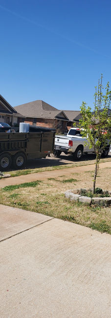 A truck parked in front of a house, getting ready to load and remove unwanted items and debris.