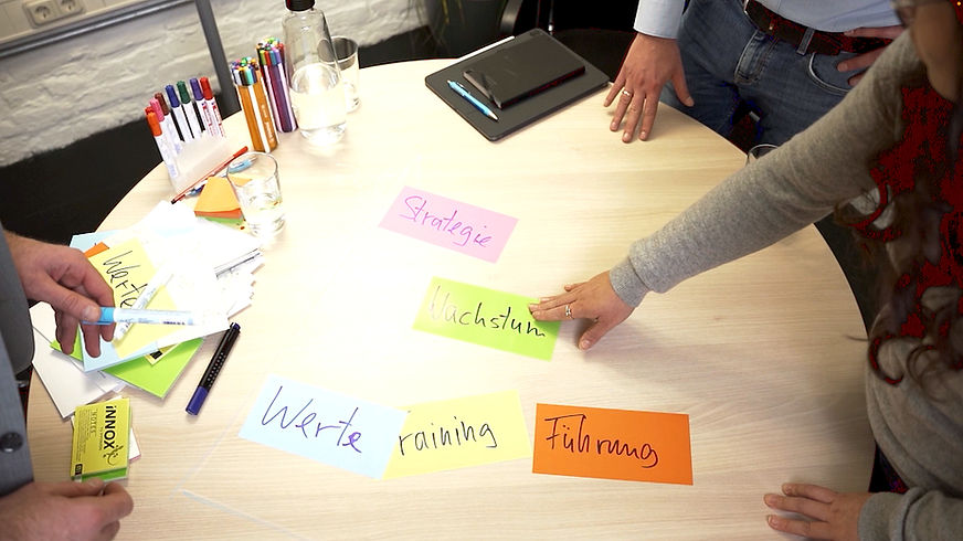 Teilnehmer bei Klausur-Tagung mit Moderationskarten und Arbeitsmaterialien