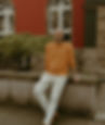 Felix Schlebusch, Experte für Unternehmer-Coaching im Ruhrgebiet, in lässigem Business-Look mit orangefarbenem Pullover vor historischem Gebäude. Die Aufnahme vermittelt Authentizität und Zugänglichkeit und unterstreicht den Leitsatz 'In unsicheren Zeiten wird innere Klarheit zum wichtigsten Kompass des Unternehmers'