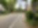 Road with trees and houses lining the sides, a "North Maryland 97" sign on the right, and cloudy sky above. Quiet suburban scene.