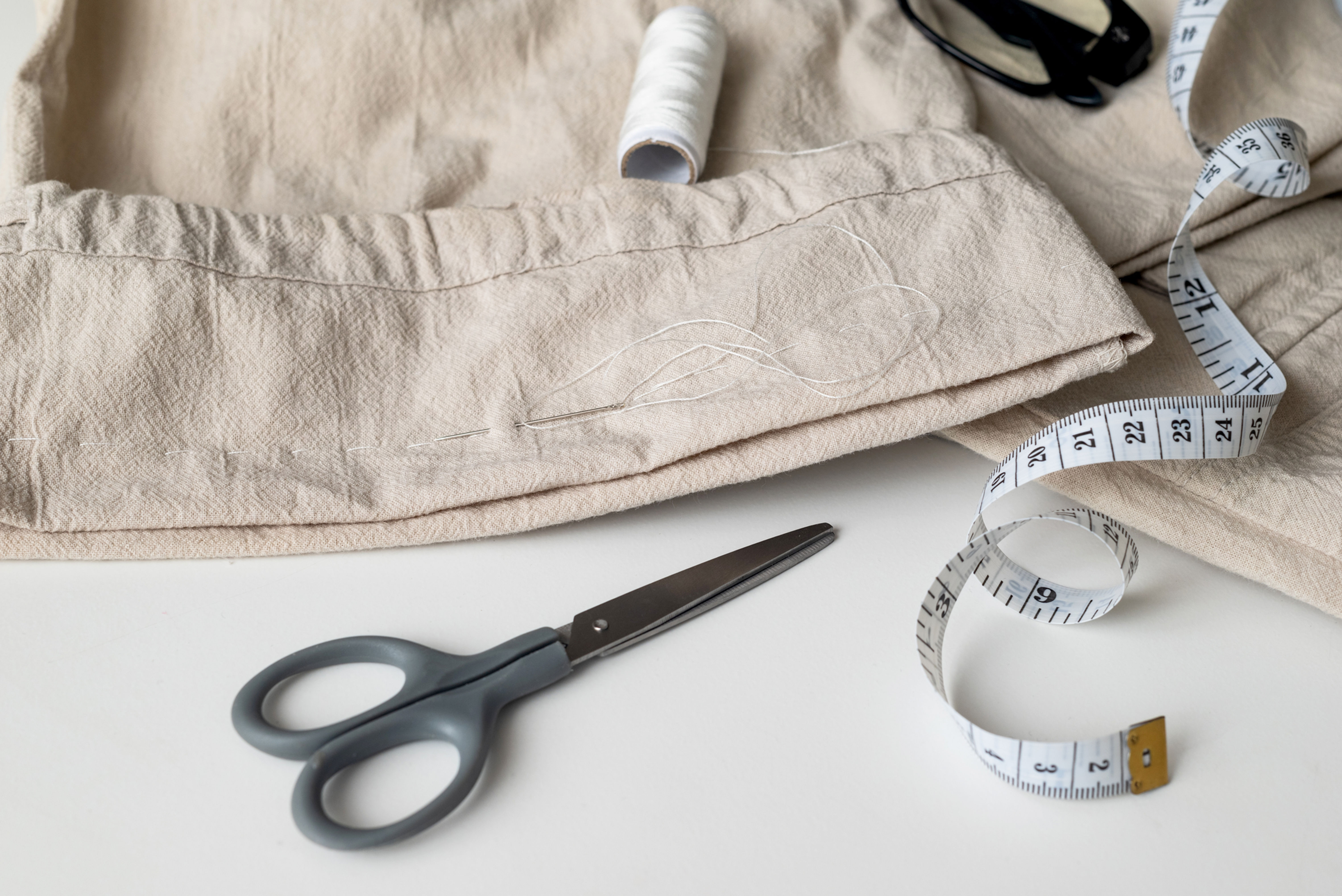 Image of scissors, measuring tape, and pants