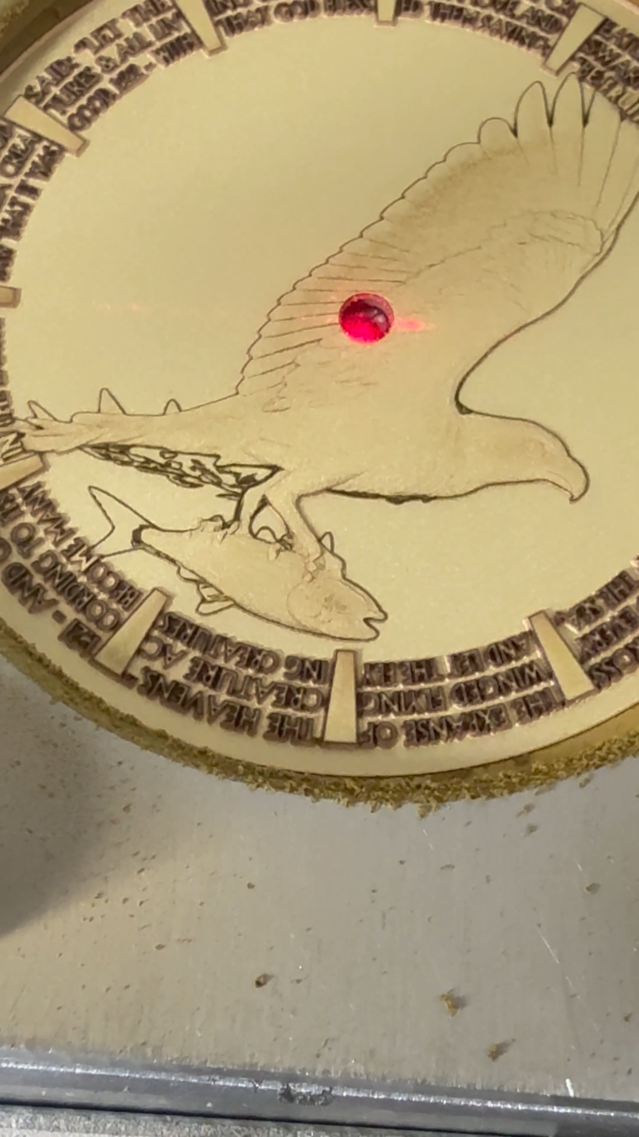 Laser engraving an eagle design onto a watch dial.