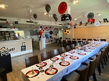 Festlich dekorierter Raum mit Tisch, Ballons und Servietten, für Rockabilly-Party