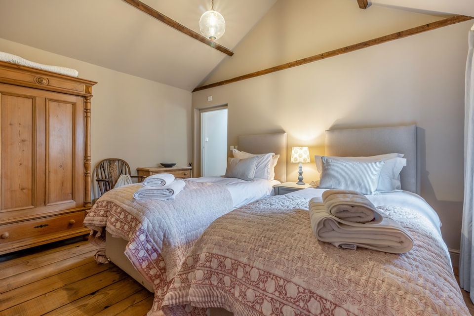 Stable Cottage Bedroom - featuring a zip and link super king bed, ensuite bathroom, and vaulted beamed ceiling