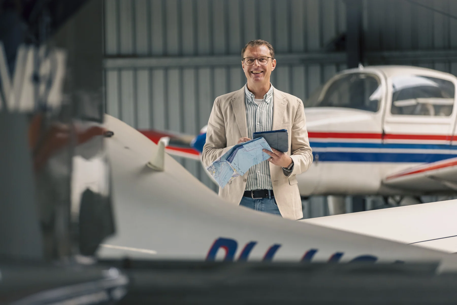 Bart van den Tol in de hangar met vluchtkaart en tablet