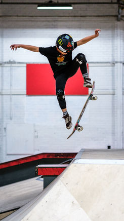 Skater springt boven een ramp tijdens een schoolse activiteitendag.