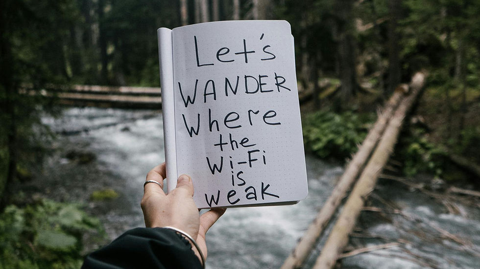 woman holding notebook with words let's wander where the wifi is weak