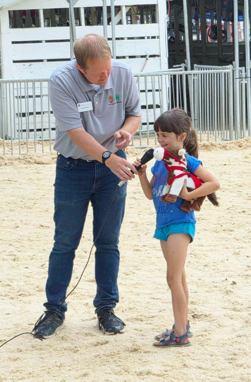 Molly Beyrer with Dunn County 4-H Educator, Zachary Rozmiarek as she introduces her stuffed horse at the Stuffed Animal Show at the Dunn County Fair | Photo by Jennifer Rozmiarek