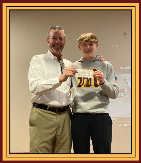 Booster Club President Andy Lamb accepts a check from Kiptyn Hillman.