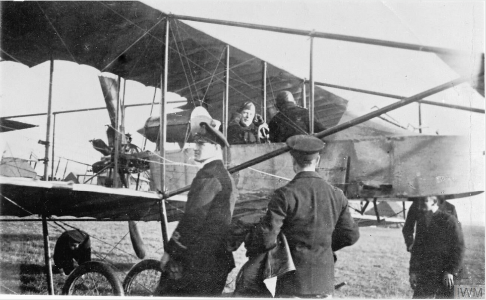 First Lord of the Admiralty, Winston Churchill, sits in Short-Sommer Pusher Biplane, T2, of the RFC (Naval Wing), while learning to fly at Eastchurch, Kent. In the foreground, facing left, is Lieutenant G V Wildman-Lushington, Churchill's favourite instructor, who was killed in a flying accident the month after this photograph was taken. (© IWM CH 4779)