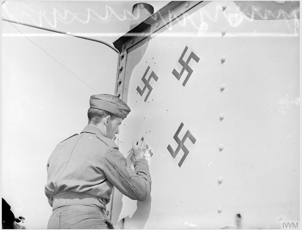 Here four enemy aircraft destroyed by SUNK HEAD Fort's guns are recorded by swastikas on the side of the "Bridge". The fourth one is being painted on by a member of the fort's crew. Image also at © IWM A 19008