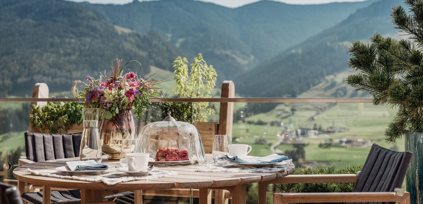 Gedeckter Frühstückstisch auf der Terrasse mit Blick auf die Bergwelt in den Senhoog Luxus Chalets in Leogang
