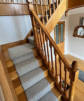 A grey carpet running up the stairs of a cottage