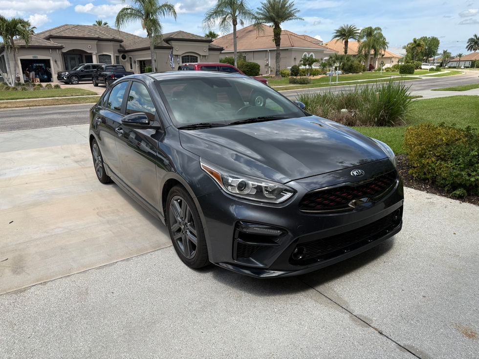Black car parked in residential driveway.