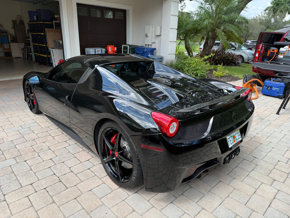 Black sports car parked on a driveway.