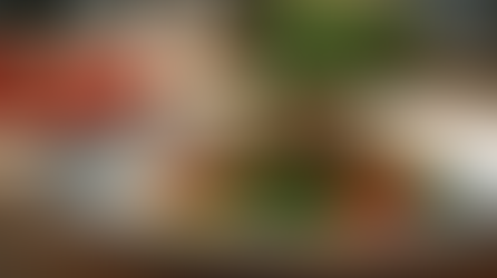 Sappig gegrild biefstukje op een wit bord met geroosterde groenten, cherrytomaatjes en een takje rozemarijn, geserveerd op een houten tafel