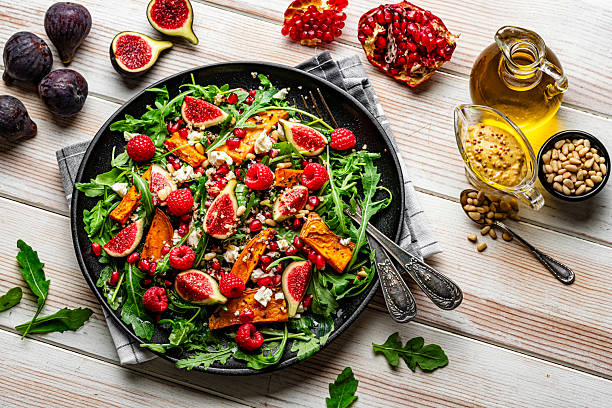 Keto wintersalade met feta, noten en geroosterde groenten in gietijzeren pan