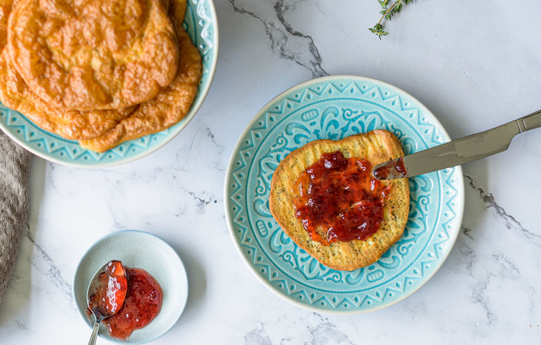 Goudgele oopsie broodjes met jam op bord -- koolhydraatarm brood alternatief recept