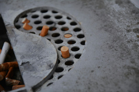 Asbak met sigarettenpeuken in yin-yang vorm als symbool voor stress, roken en hardnekkige patronen.