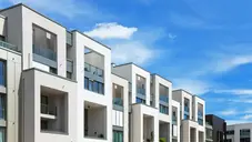 Moderne mehrstöckige Wohngebäude mit Balkonen vor blauem Himmel 