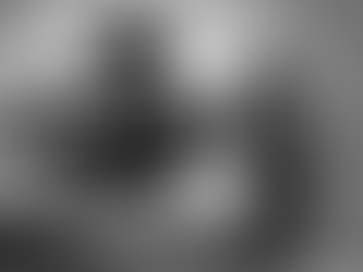 Black and white photo of a woman and man sitting apart on a couch, looking away from each other, the mood tense and emotionally disconnected. The man rests his chin on his hand while the woman sits in the foreground holding a mug, her expression downcast. Stella Dove, trauma-informed Inner Child Healer, writes “What Is the Inner Critic (and How Do You Heal It)?”, a trauma-informed reflection exploring how early emotional wounds and sensitising events shape the harsh inner voice and how Emotional Recalibration Therapy helps rewire self-worth and restore inner safety.