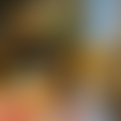 Vase with yellow and white flowers on a table, next to a lit candle. Cozy room with bookshelves, a sofa with yellow pillows, and a window.