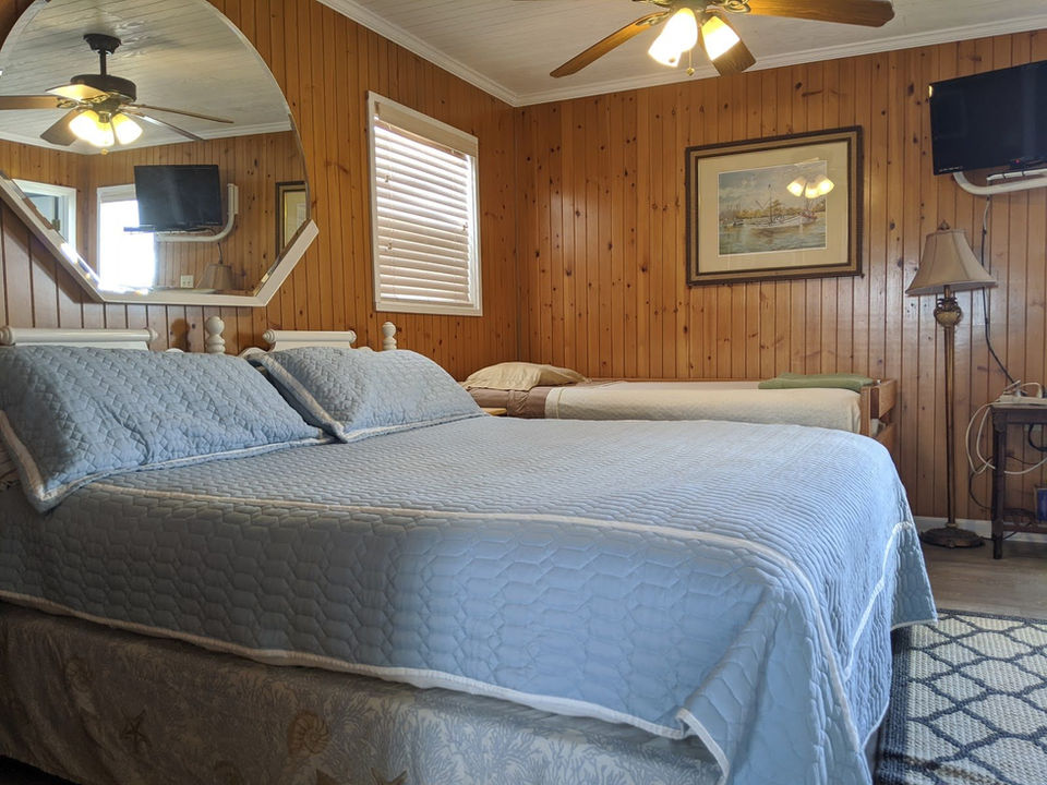 King bedroom with blue bedding at Pelican's View Lodge waterfront rental in Cocodrie, LA