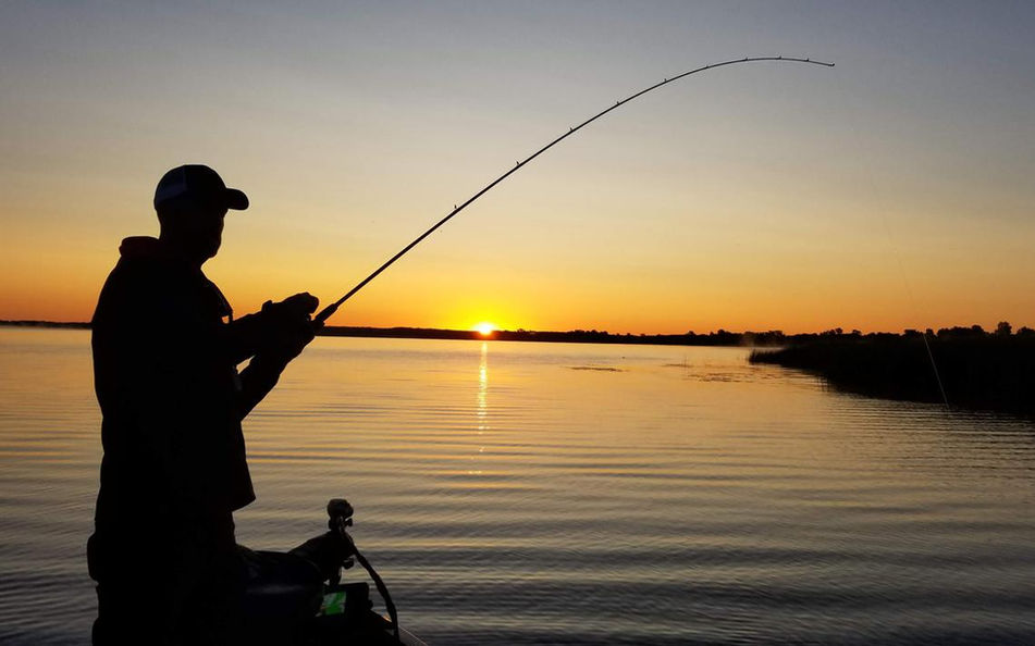 Silhouette of angler fishing at sunset from Pelican's View Lodge dock in Cocodrie, Louisiana